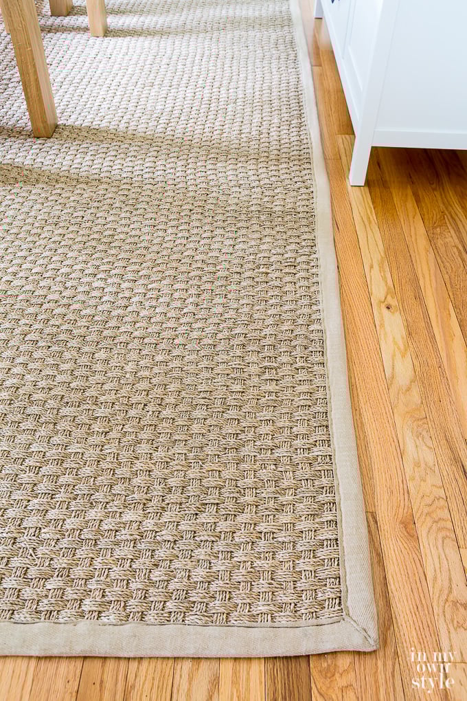 Seagrass rug with neutral beige trim in dining room.