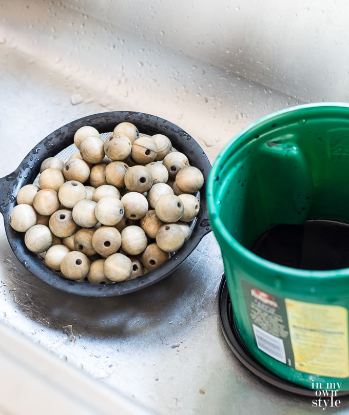 Staining wood beads with driftwood stain in a kitchen sink