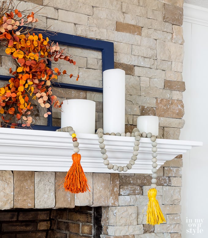 Wood bead garland on fall decorated fireplace mantel