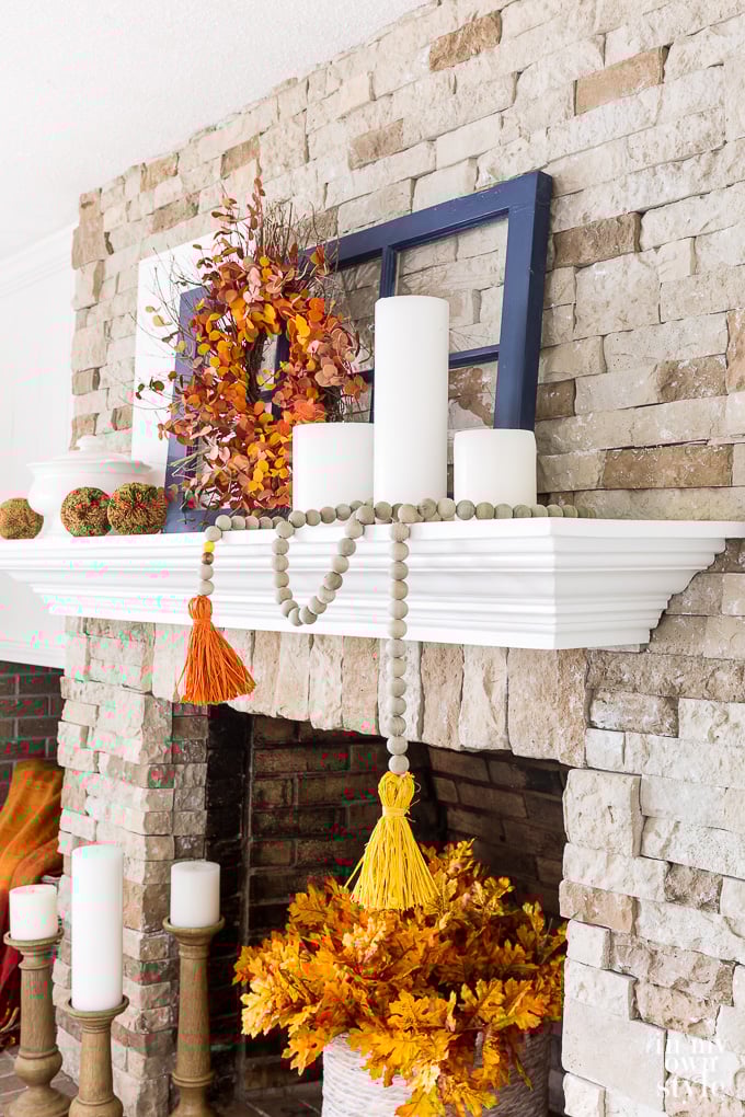 Fall mantel decorated using orange yellow and navy blue