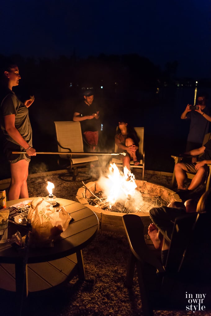 Family roasting marshmallows around a backyard firepit