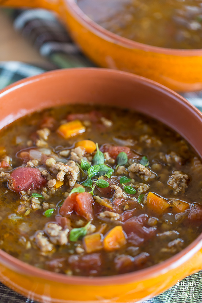 Close up shot of Sausage and Lentil Soup in an orange bowl