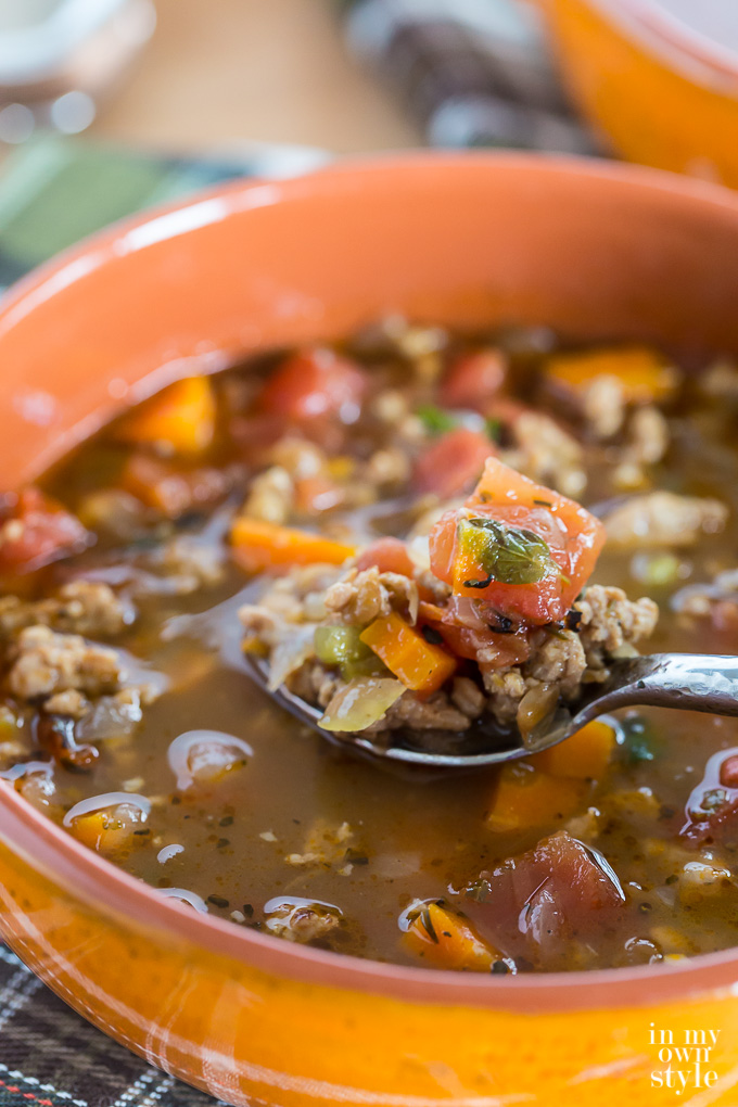 Sausage and lentil soup in a big orange bowl