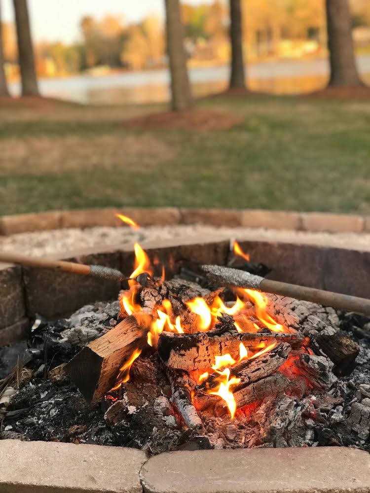 Roasting marshmallows over an outdoor firepit using DIY roasting sticks 