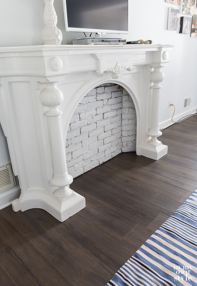 Wood laminate floor in bedroom with white mantle and light blue walls