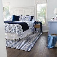 After photo showing how new wood laminate flooring looks in blue and white bedroom