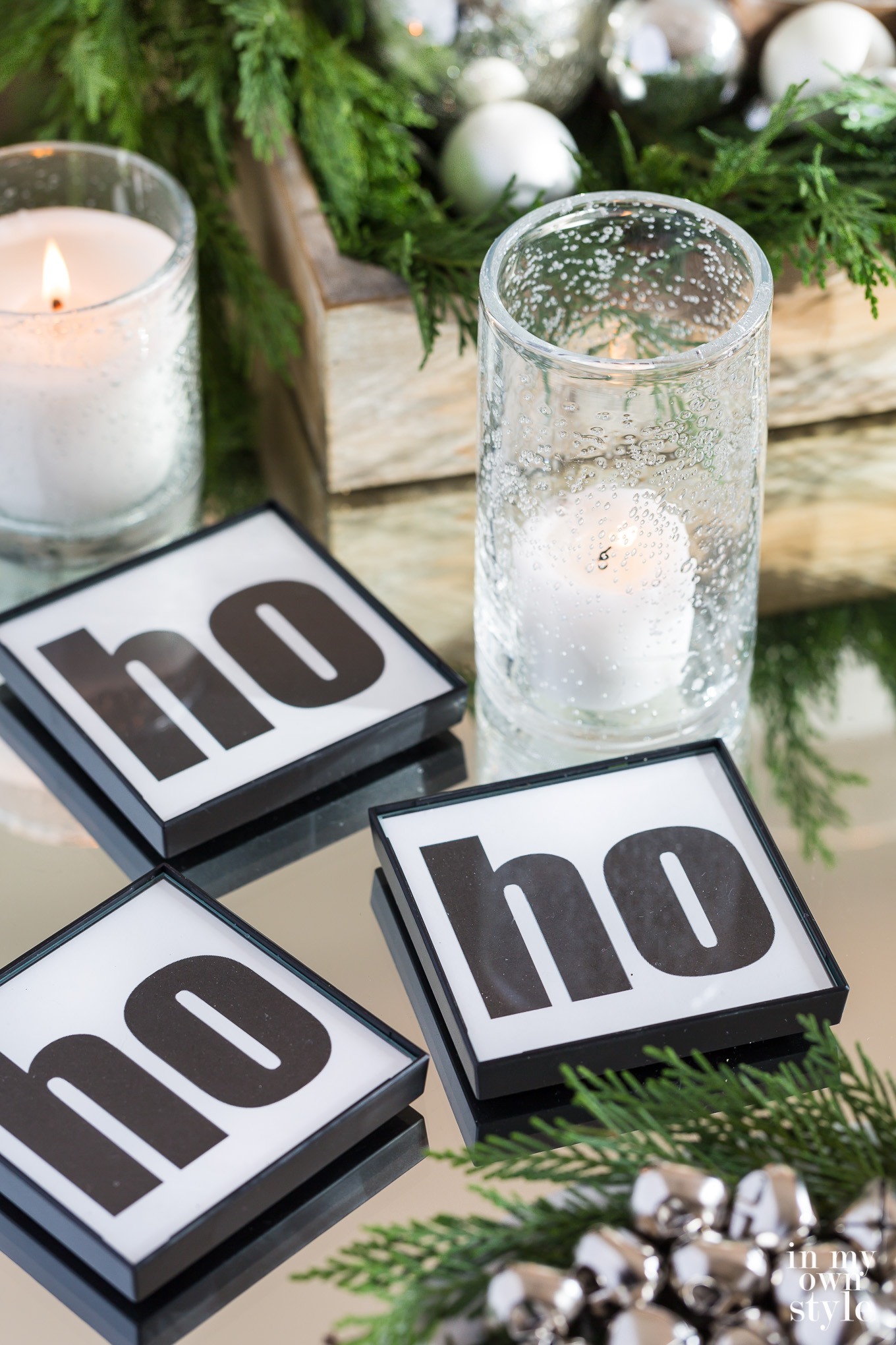 DIY black and white HO HO HO coasters on table