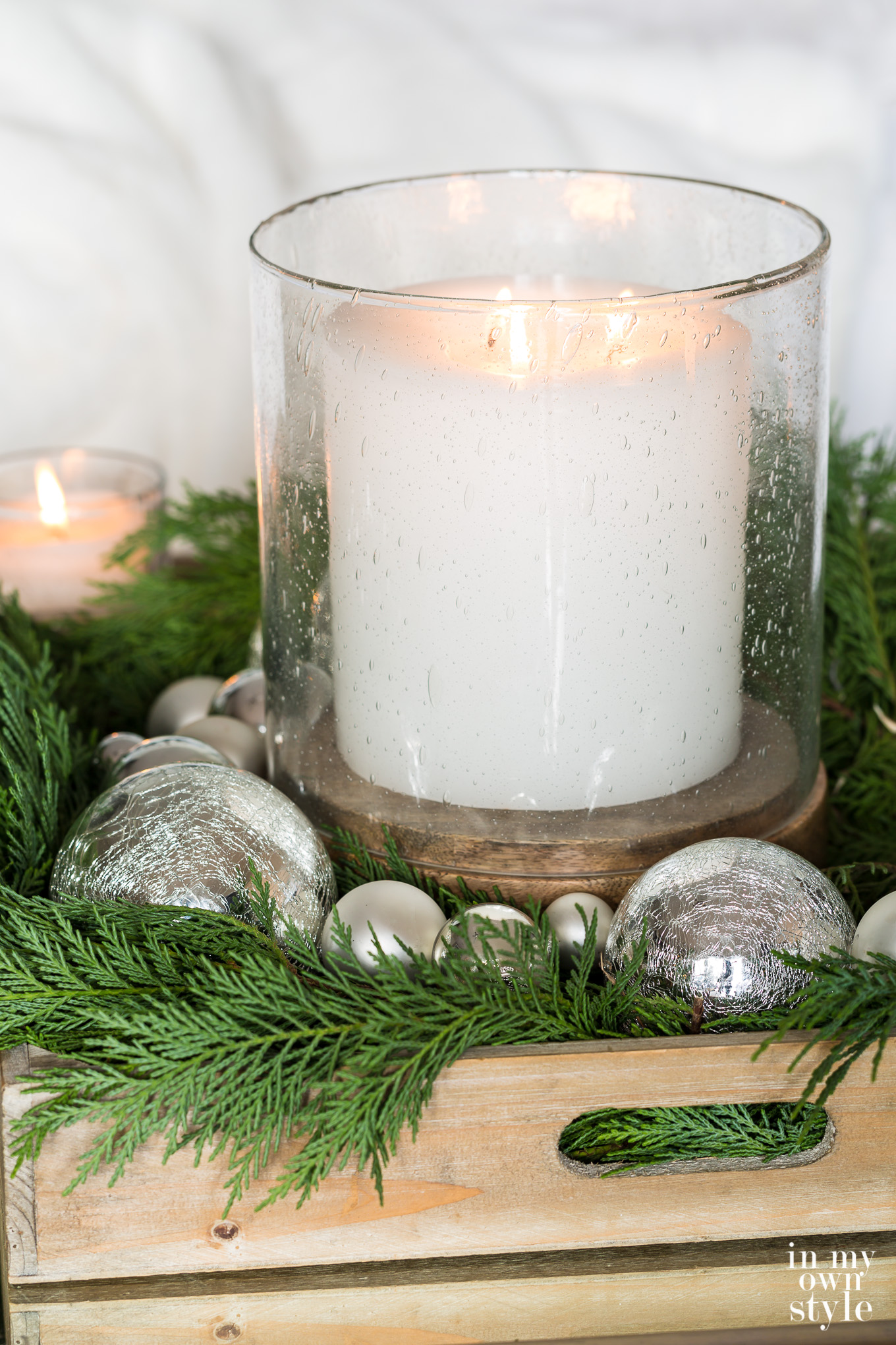 Bubble glass hurricane with large white candle inside.