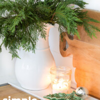 White ceramic pitcher with sprigs of cedar. Simple and natural Christmas decorating ideas