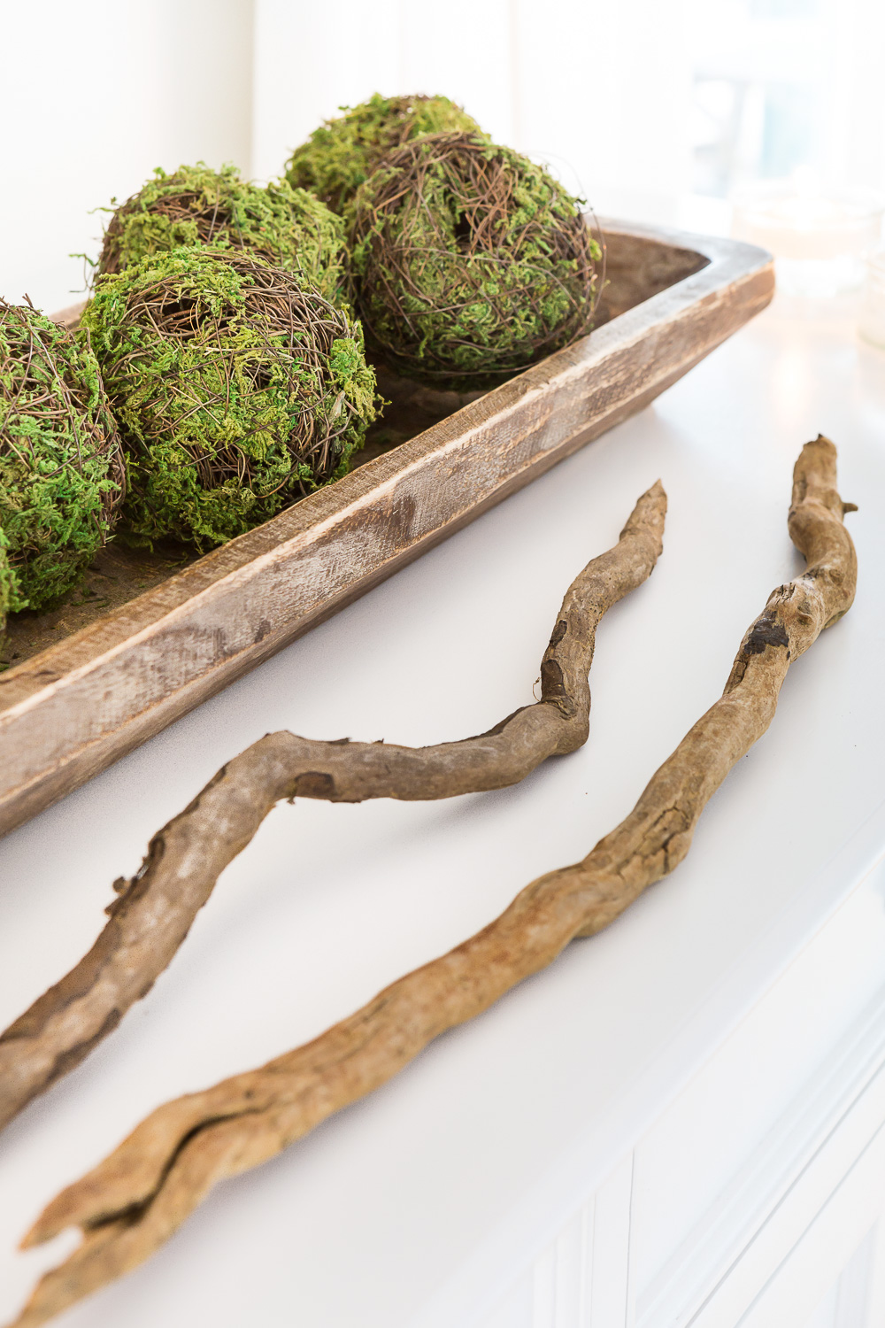 How to use items from nature to decorate the top of a TV console.