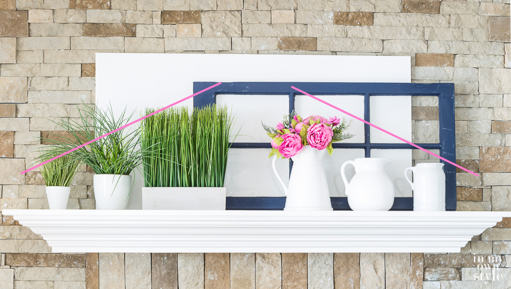 Using a collection of white pitchers to decorate a mantel.