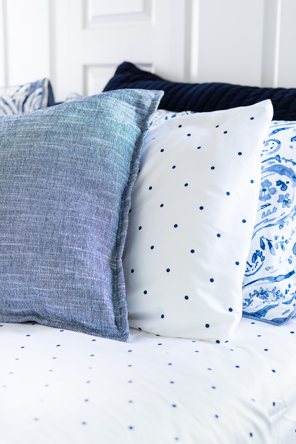 3 Blue and white bed pillows on a bed