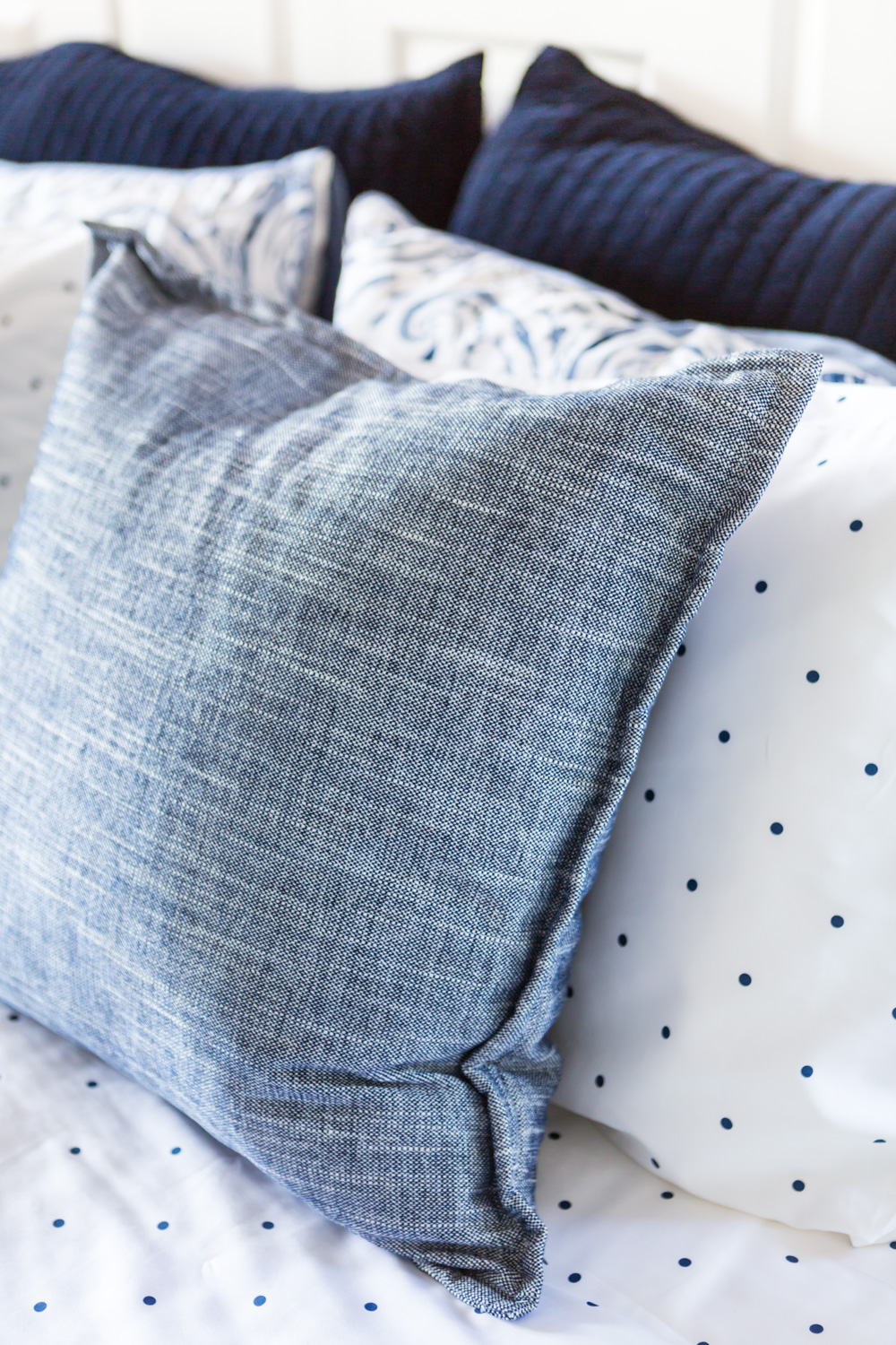 Blue and white pillow on bed