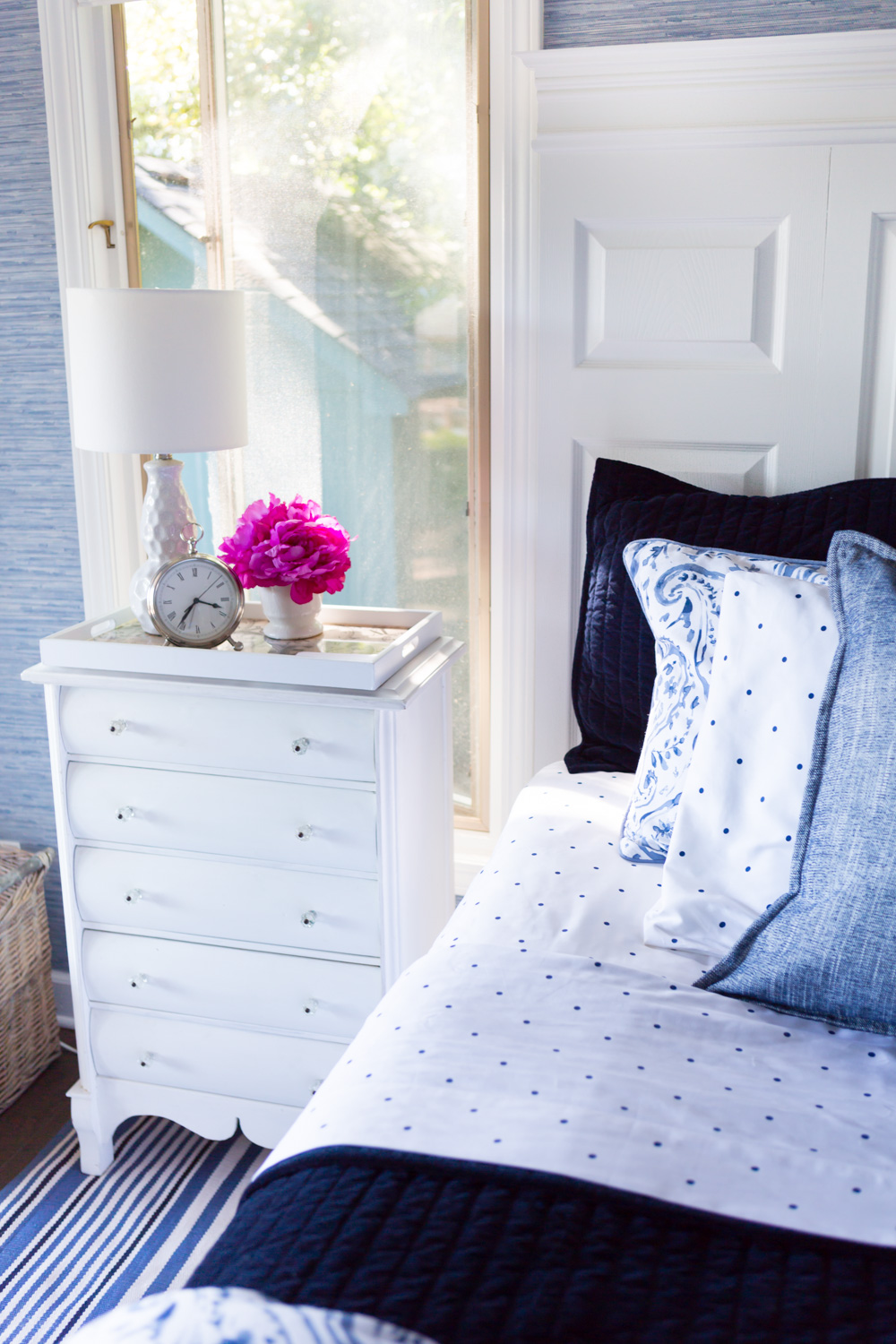 White painted furniture in blue and white decorated bedroom.