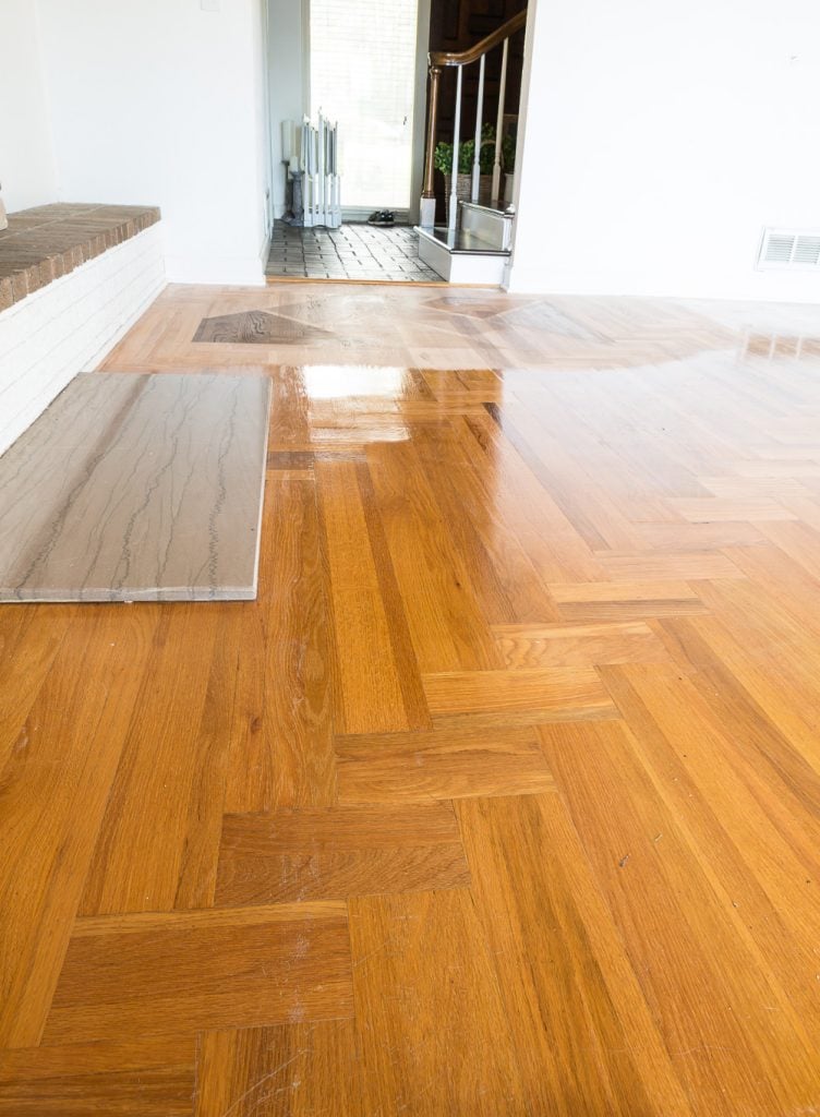 Orange toned wood floor with oil-based polyurethane before getting refinished with the Bona Hardwood Floor Refinishing System