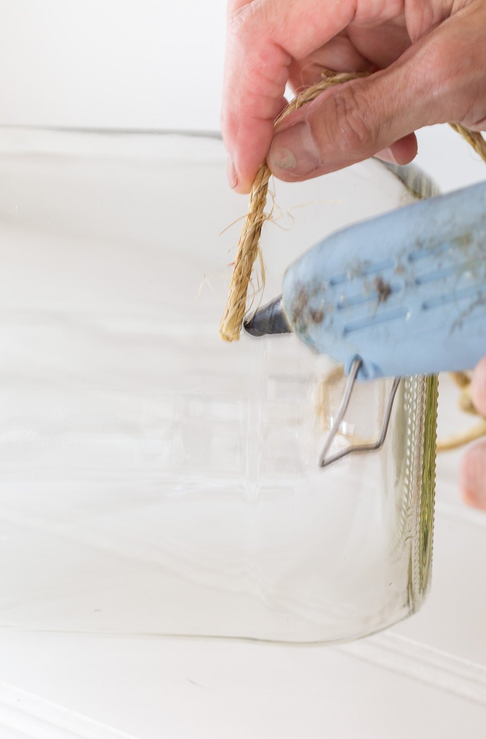 How to hot glue twine to a large glass pickle jar to make an outdoor table candle lantern