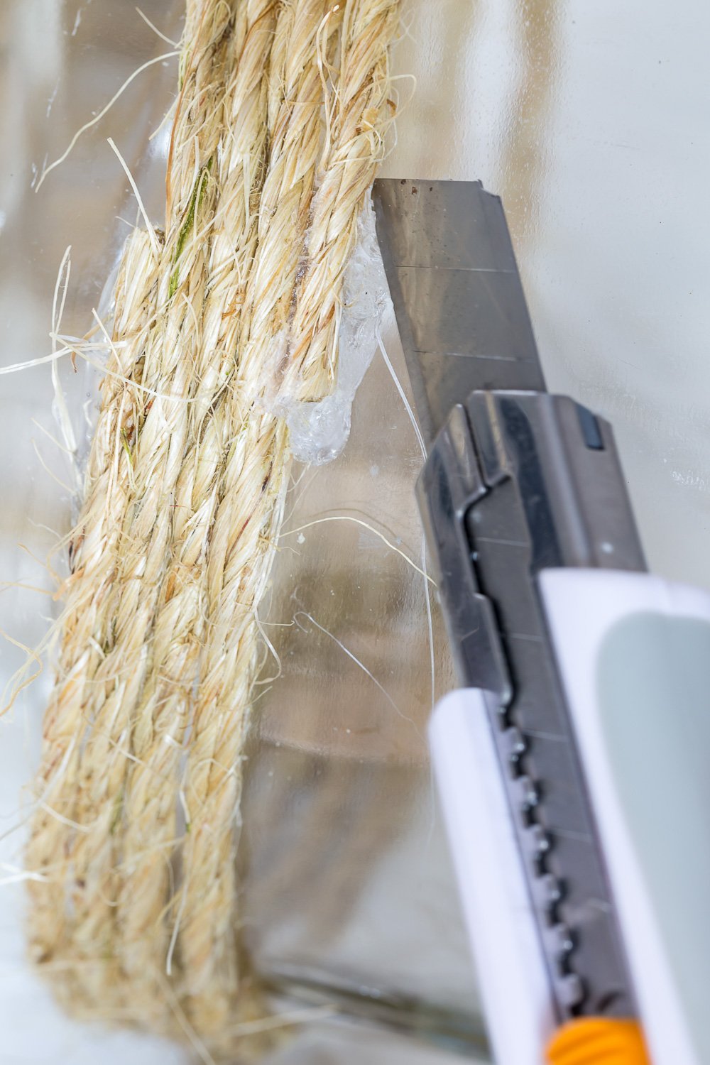 Removing excess hot glue from glass on DIY candle lantern by repurposing a large glass food jar
