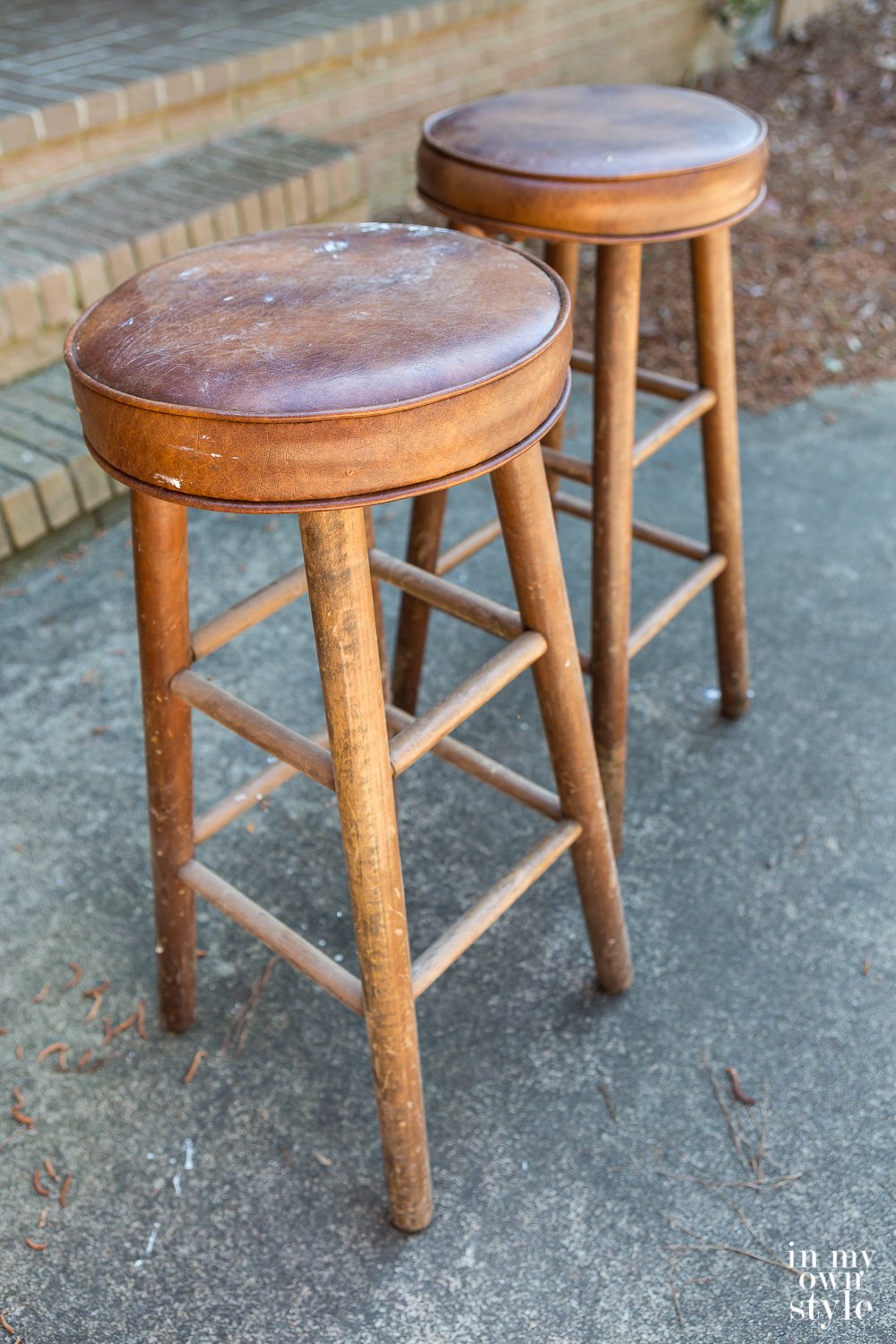 Two wood stools with pleather covered tops.