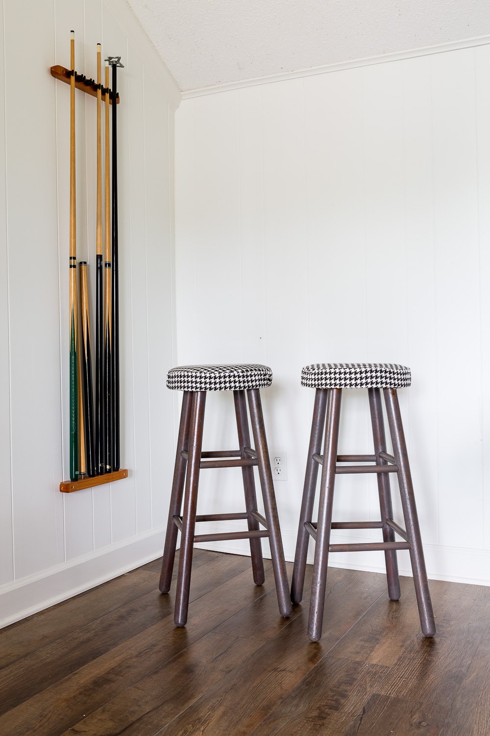Two stools after makeover with black and white houndstooth fabric covers on seats and Briarsmoke stain on legs.