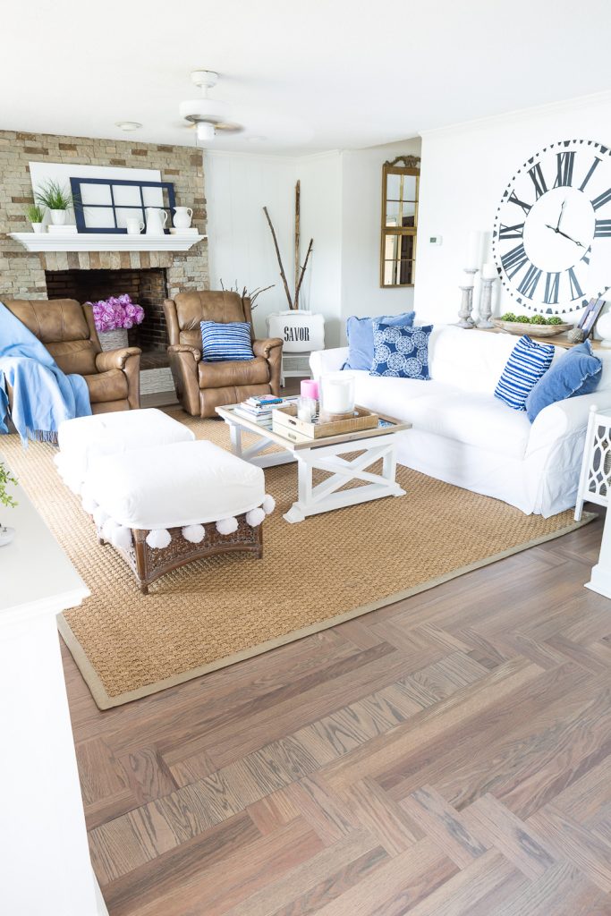 Blue and white Farmhouse style living  room with seagrass area rug with a newly painted color on the border.