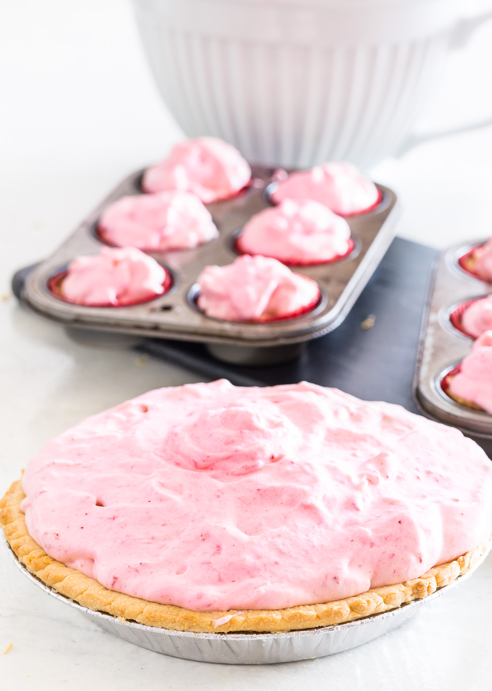 Frozen pie and cupcakes on a counter ready to go in freezer.
