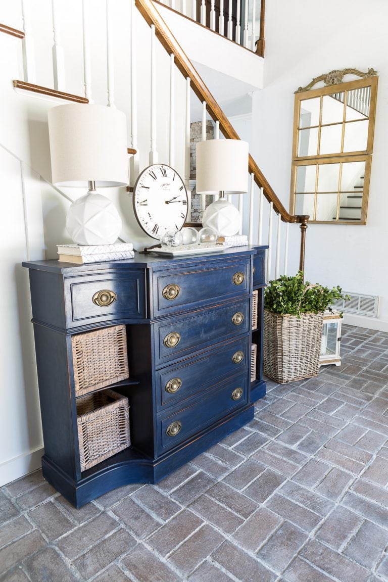 Entryway with whitewashed brick floor and navy blue chalk painted sideboard