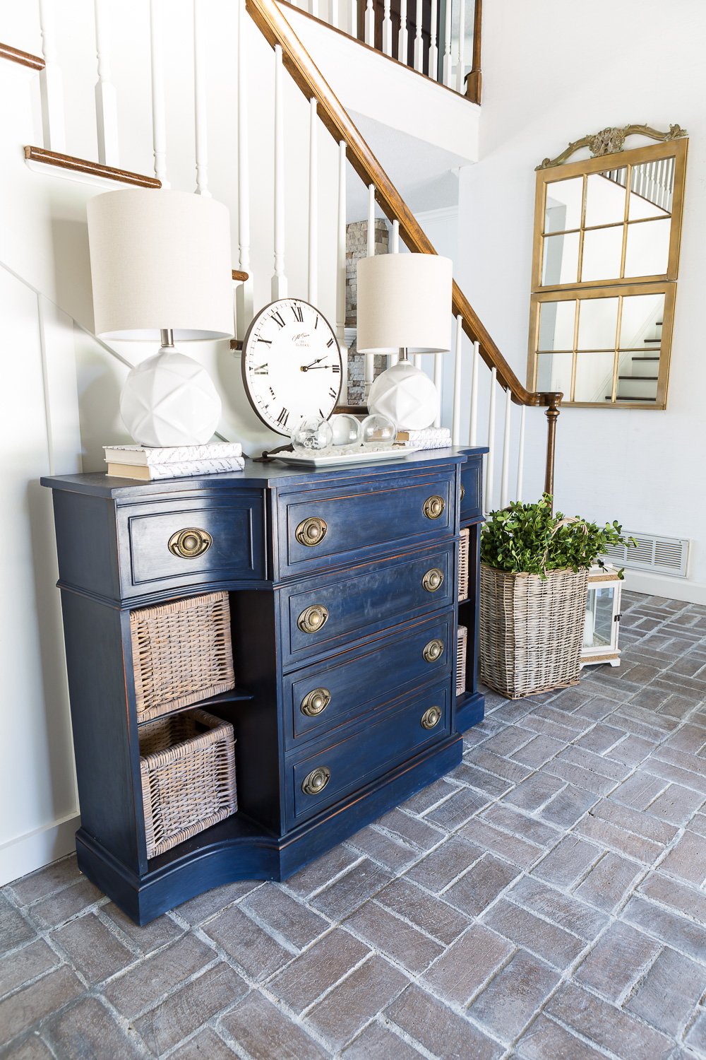 Entryway with whitewashed brick floor and navy blue chalk painted sideboard