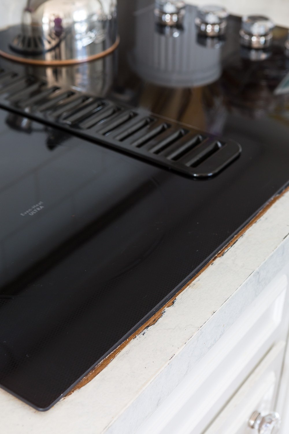 Painted counter showing exposed previous Formica after a new cooktop was installed.
