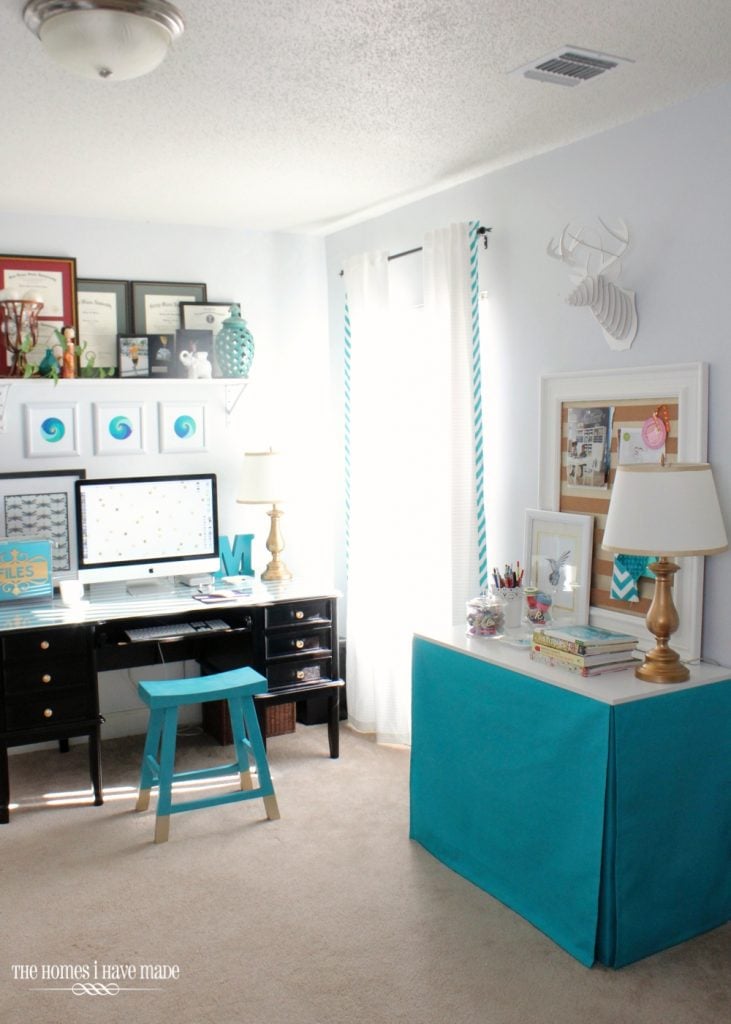 A turquoise fabric covered rectangular table in home office. 