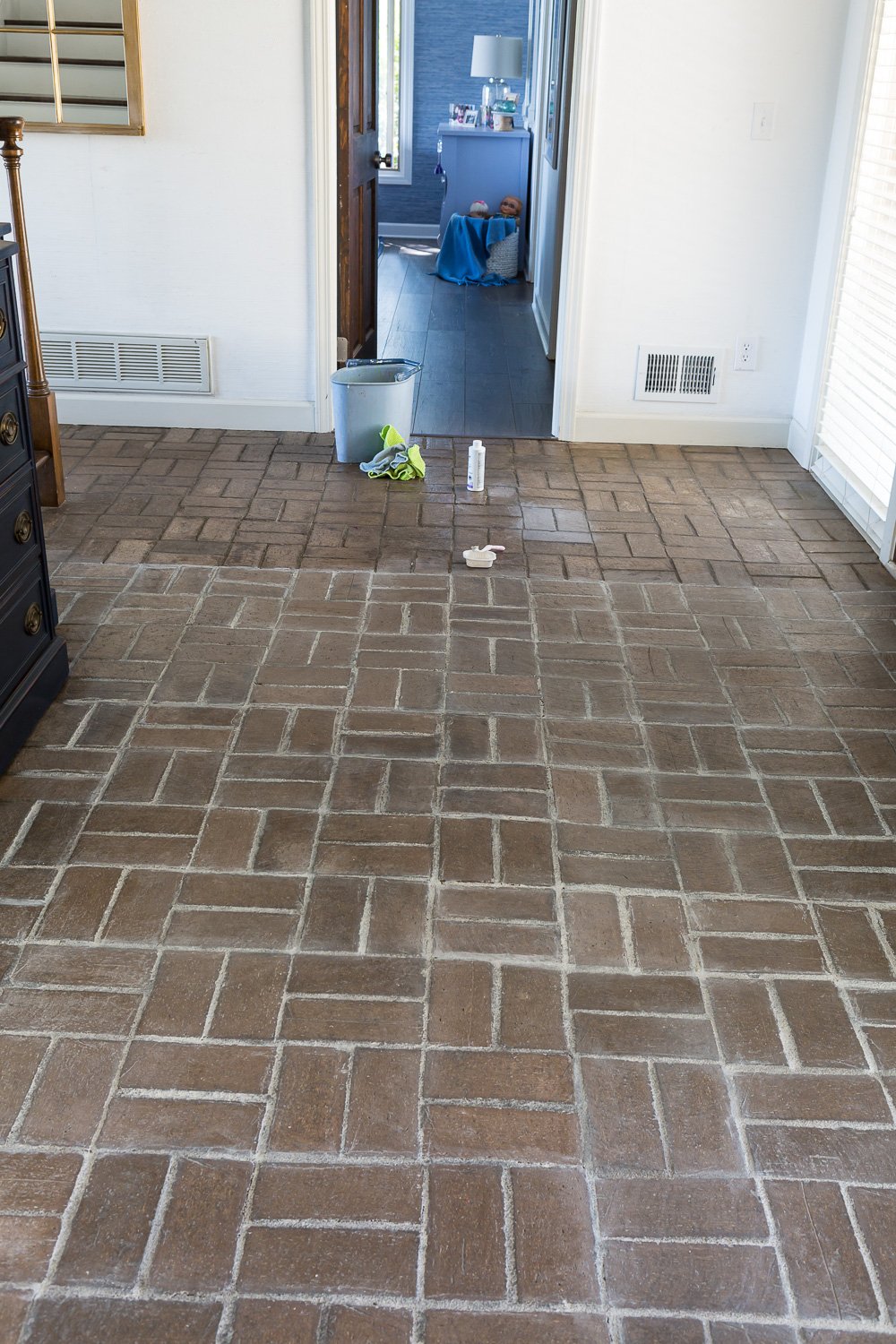 The how to tutorial showing the process of how to add a layer of color wash in this case white over a brick floor.