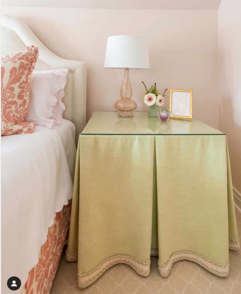 Square table with pleated skirt around it.