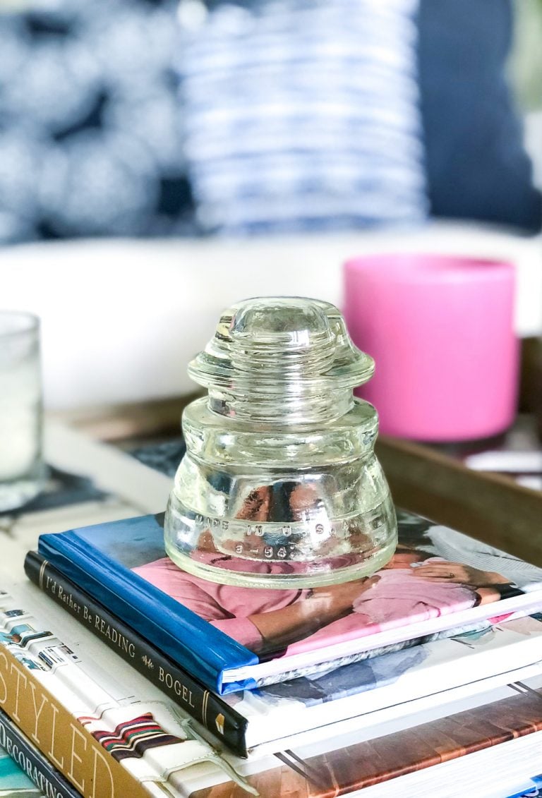 Vintage glass insulator on stack of books on coffee table