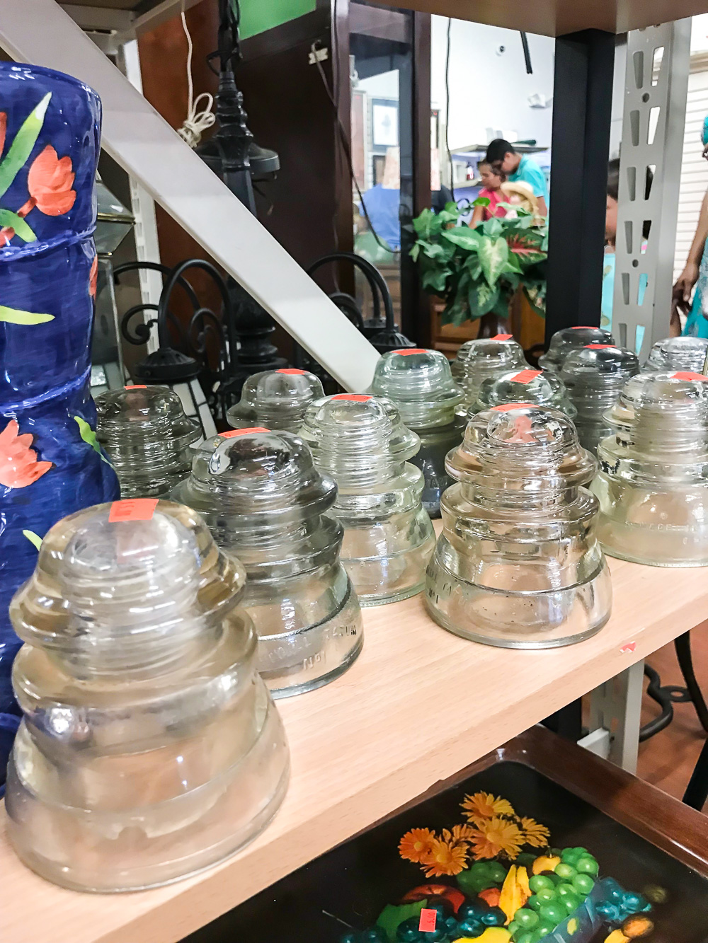 Vintage glass insulators on a thrift store shelf can create meaningful decor to make a house a home. 