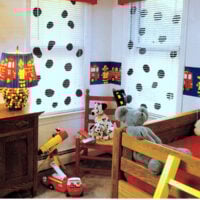 Two windows in a kid's room that have white mini blinds with Dalmatian spots.