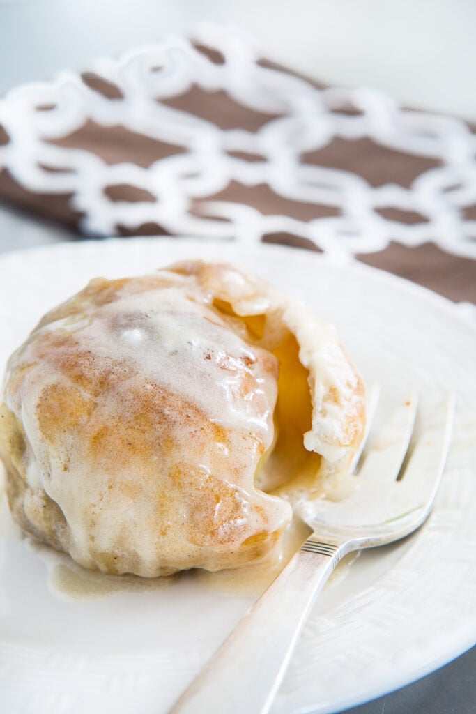 a baked apple wrapped in piecrust on a plate ready to be eaten