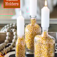 fall candle holders made using clear glass bottles and popcorn on a coffee table