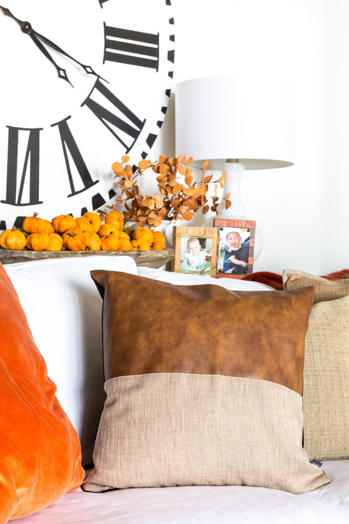 Leather throw pillow on sofa in fall decorated room