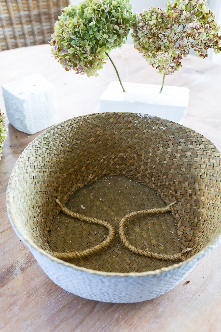 Collapsible Rattan tote on table getting prepared to be used a dried flower vase.