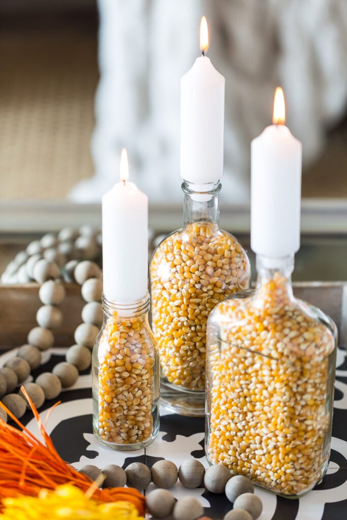 DIY Fall candle holders made from glass food bottle and popcorn kernels