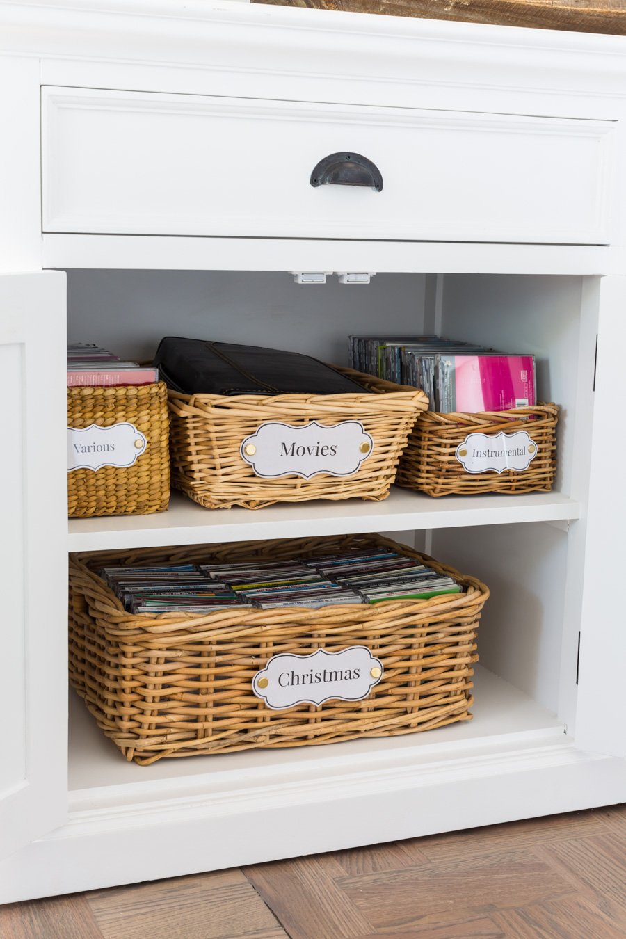 Transformed thrift store baskets with handles into stylish storage inside a cabinet.