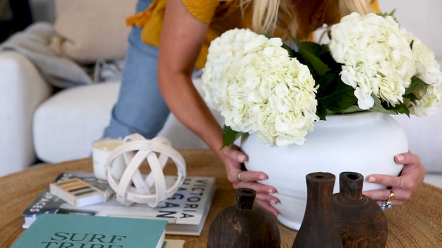 White terracotta ceramic glazed planter vase being placed on a coffee table