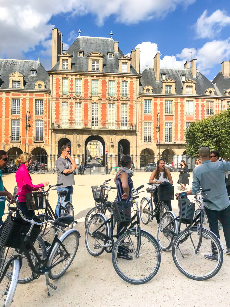Guided Bike tour in Paris. Bike tour stop at Place des Vosges in Paris.