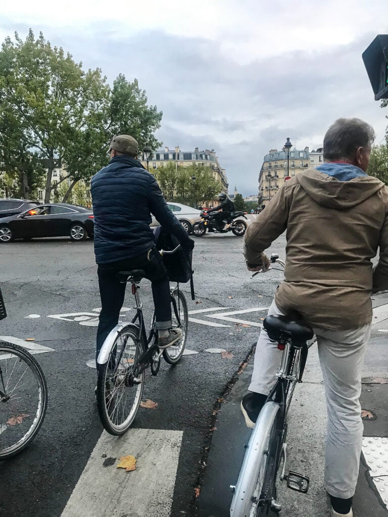 Paris bike tour at night. Simon from Bike About Tours leading a group of tourists on bikes through the back streets of Paris.