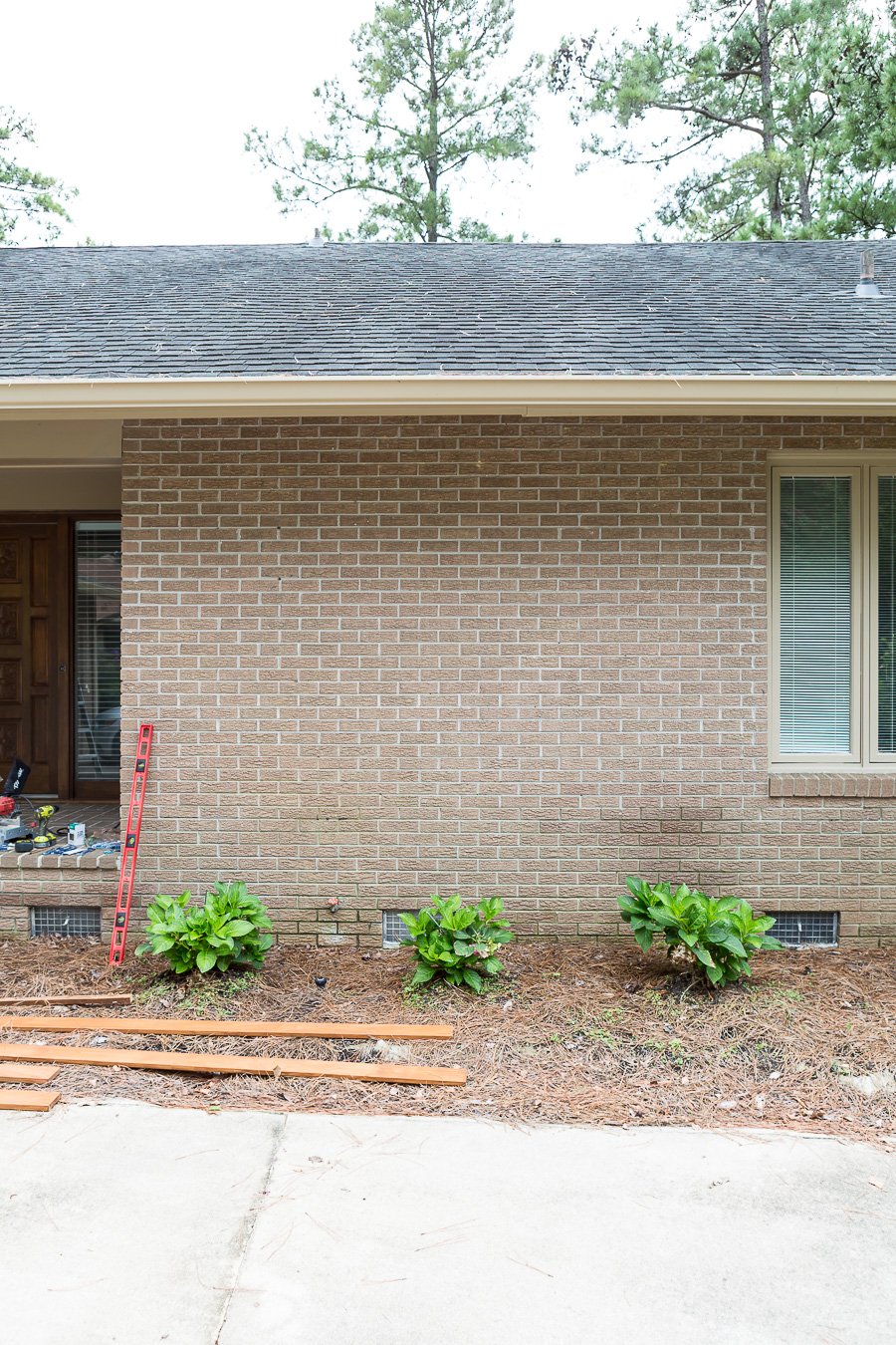 Before photo of plain brick Ranch style home