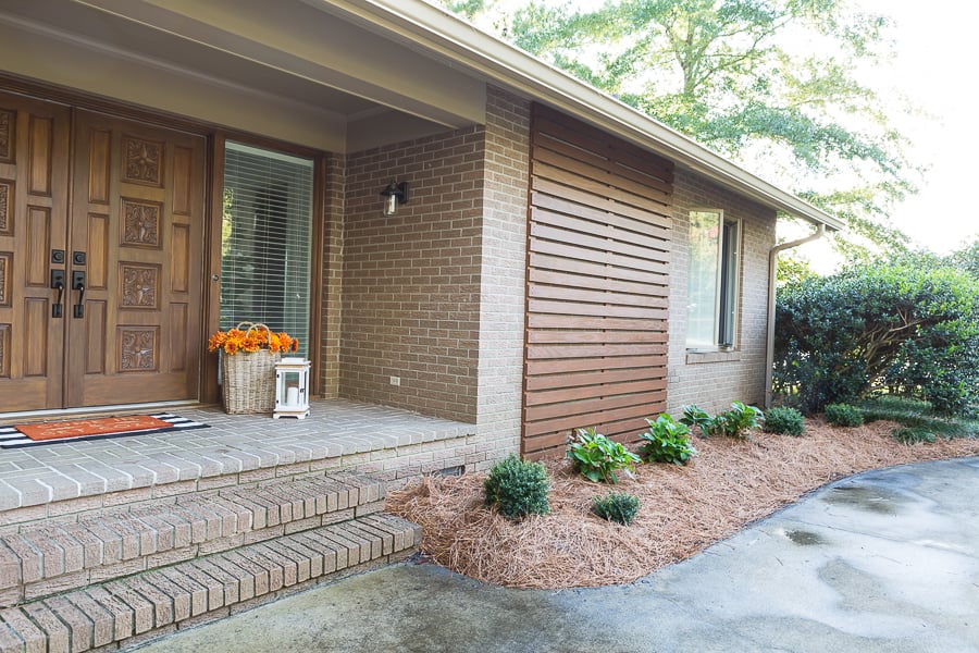After image of an exterior wood accent wall on the front of a brick home.