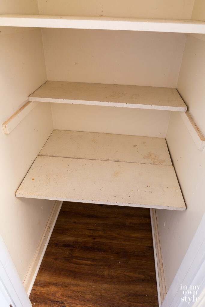A small hall closet getting prepared for a makeover using primer and paint.