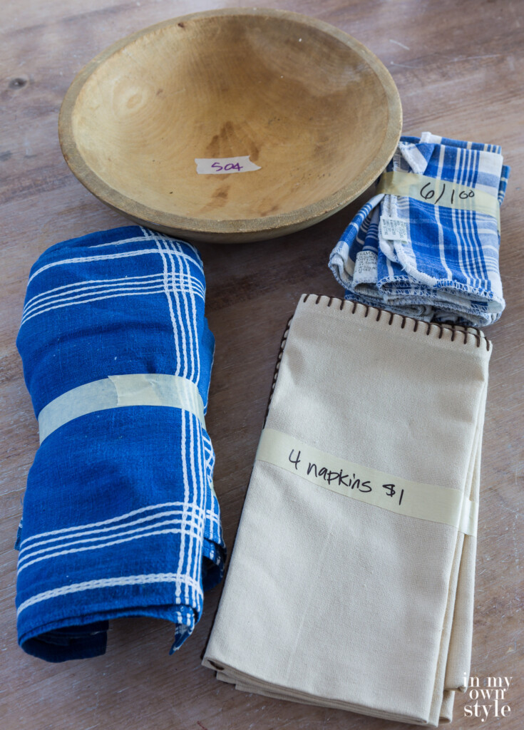 Church bazaar trash to treasure shop finds. Blue and white table linens and a wood bowl