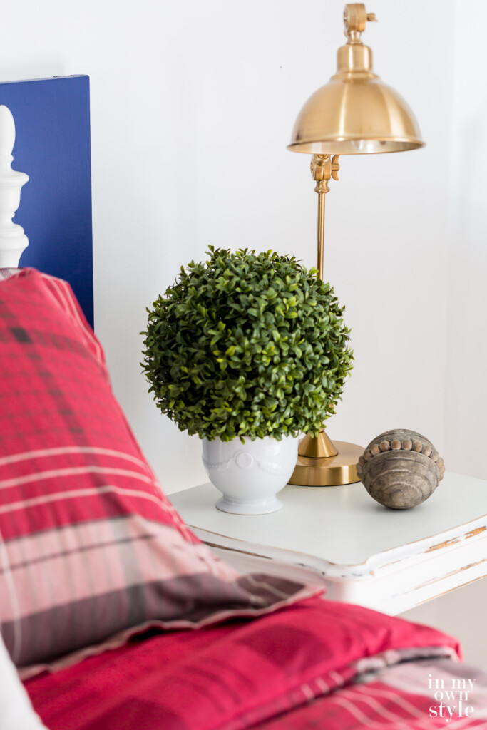 Beside table in guest room with red plaid color scheme.