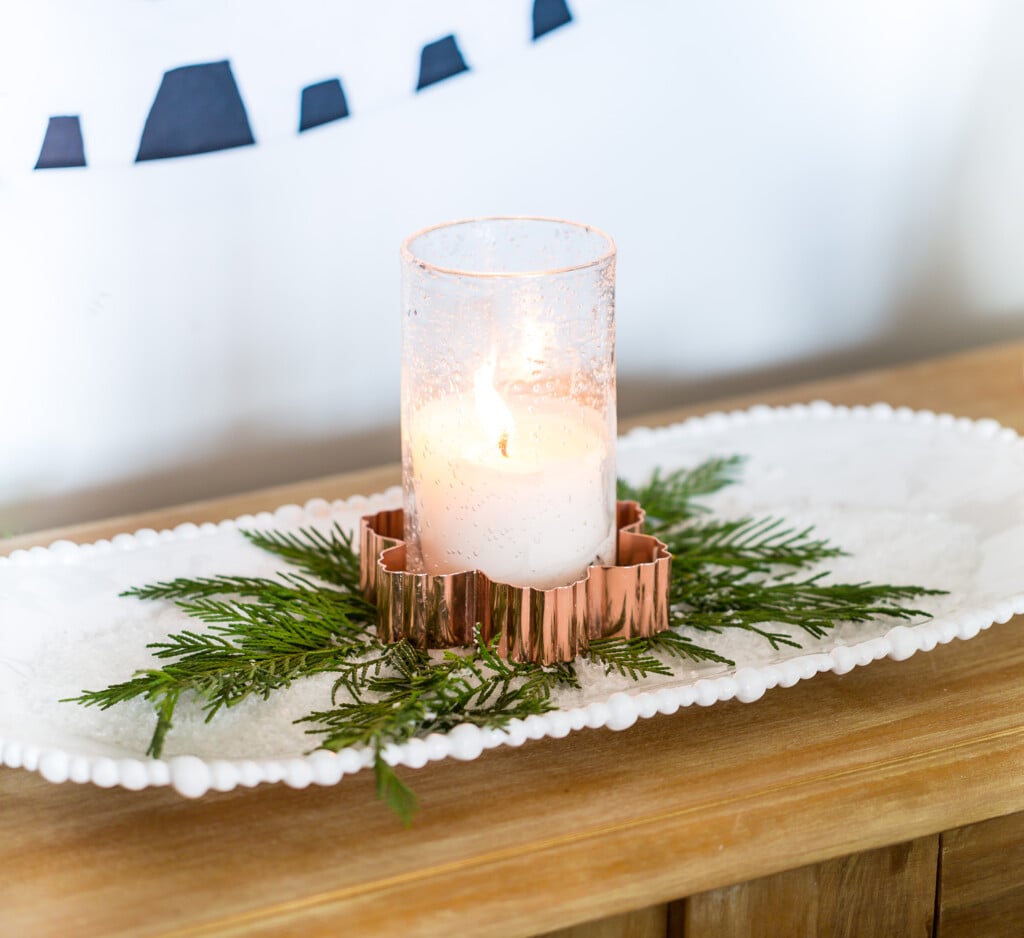 Candle placed inside a copper snowflake cookie cutter on a tray of salt makes for easy to do last minute Christmas decorating