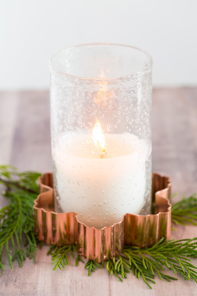 A glass candle and holder placed inside a copper cookie cutter makes for fast and easy Christmas decor